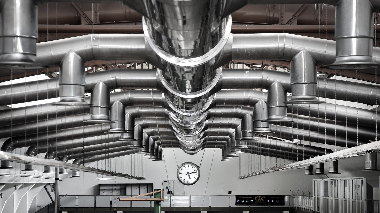 Spiral ductwork and fittings suspended from the ceiling. An example of items that are sold in Mr Spirals duct store